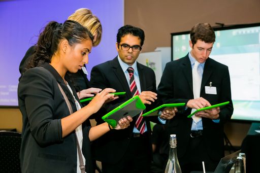 Johannesburg, South Africa - January 21, 2014: Diverse business persons going over data on digital devices at a meeting