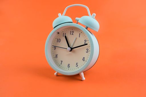 An alarm clock isolated on an orange background