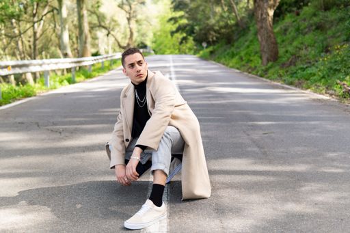 Young Hispanic Arab man posing on the road, gazing into infinity, copy space