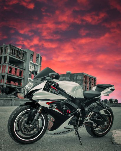 A vertical shot of black SuperBike Suzuki GSX-R 750 in the street under red dramatic sky