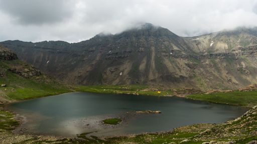 A calm lake and mountain landscape under a cloudy sky