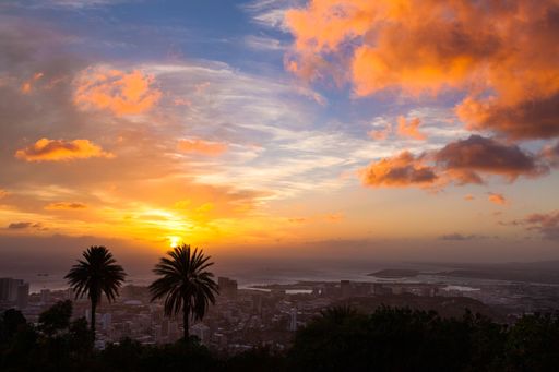 An aerial view of cityscape Hawaii surrounded by buildings during sunset
