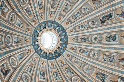 A low angle shot of a ceiling in Saint Peter's basilica with beautiful angel pictures