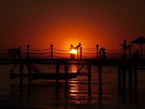 A beautiful sunset at a dock with the sunlight reflected in the water