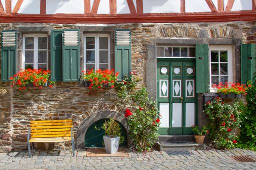 The facade of an old building decorated with plants and flowers under the sunlight in Germany