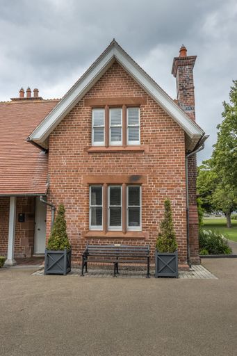 A vertical of a red brick house with a chimney and a bench in front in Dun Laoghaire district, Dublin