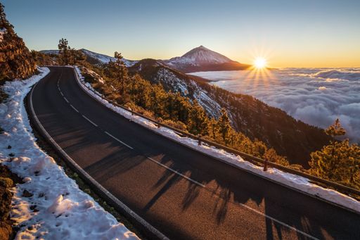 A beautiful view of the road surrounded by snow volcano on the Teide volcano background