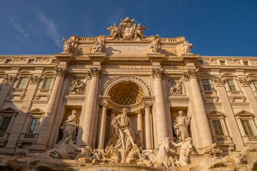Low angle shot of the famous Trevi Fountain without anyone at a golden sunset