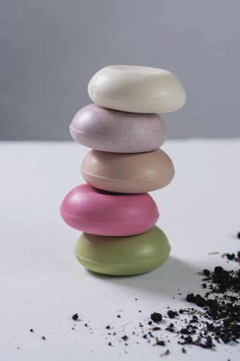 A vertical shot of colorful organic soaps on top of each other