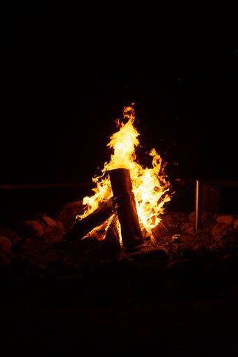 The vertical view of a campfire burning in the darkness of the night