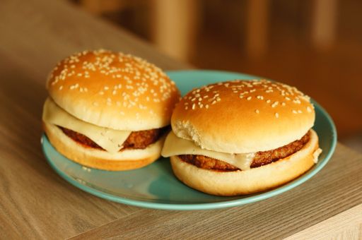 A closeup shot of two cheeseburgers in a blue plate on a table