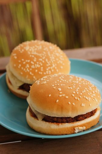 A vertical shot of two cheeseburgers in a blue plate on a table