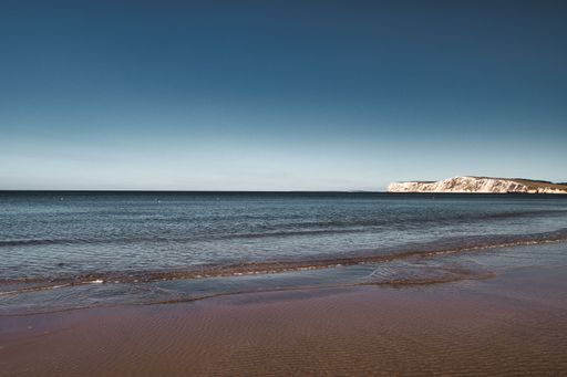 A beautiful shot of the Isle of Wight island with calm waves under a blue sky