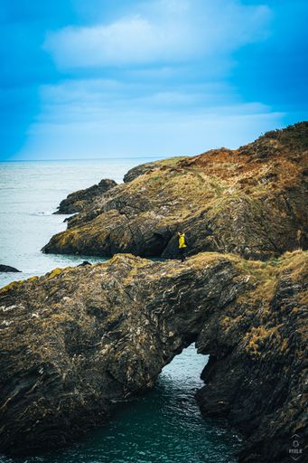 A vertical shot of the rocky cliffs and the sea