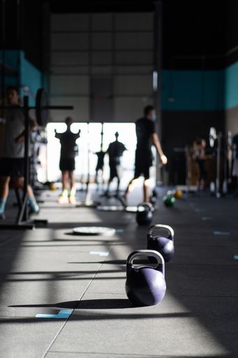 A vertical shot of dumbells on the floor in the gym