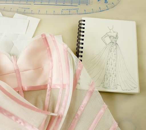 A beautiful hand-drawn dress sketch and sewing on the table