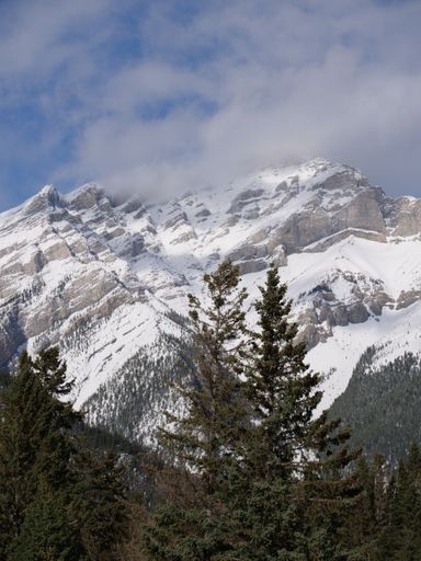 A vertical shot of  beautiful snowy mountain peaks in Banff, Alberta, Canada
