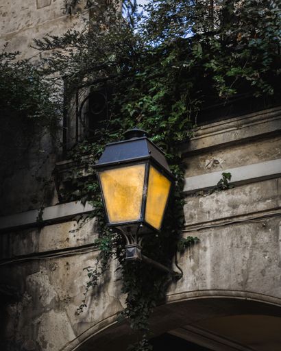 A closeup of an old vintage outdoor lamp hanging on a wall