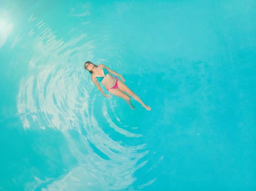 An aerial view of a hot Mexican female floating on water in a swimming pool