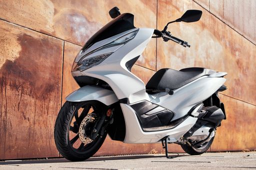 A white motorbike with rusty background