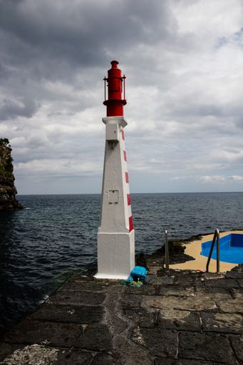 A vertical shot of a lighthouse under a cloudy sky