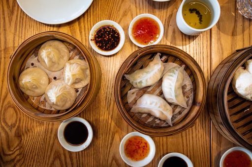 A top view of dumplings with different sauces served on a table