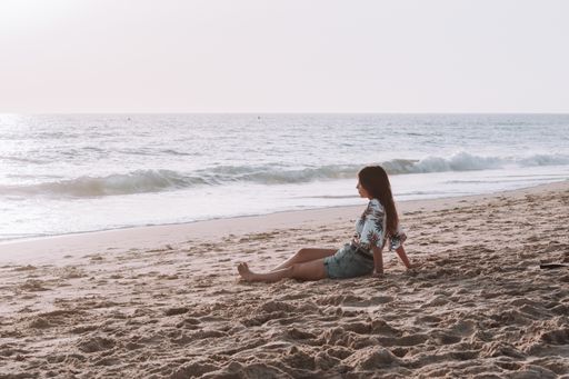 A selective focus shot of a hot young Caucasian female in shorts enjoying the beach