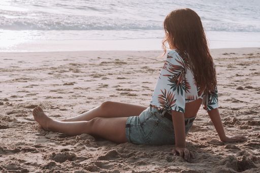 A selective focus shot of a hot young Caucasian female in shorts enjoying the beach