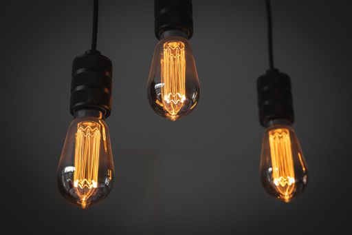 A closeup of small light bulbs hanging in a dark room