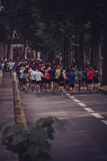 A vertical shot of many people running during an event on trail asphalt track