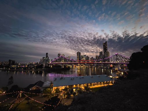 An aerial view of cityscape Brisbane surrounded by buildings and water in night
