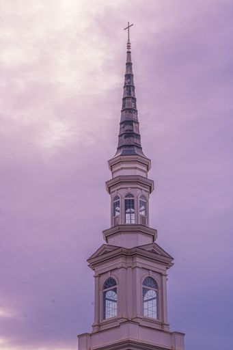 A low angle shot of church building in background of purple sky