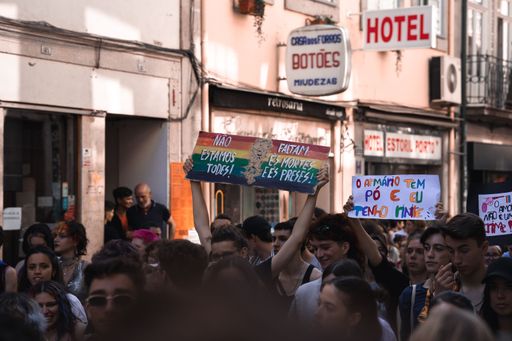 A shot of people with posters and flags participating in Pride Demonstration in Portugal, Porto