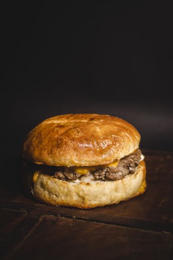 A closeup shot of fresh delicious burger on a wooden surface