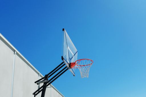 A low angle shot of a basketball hoop under the beautiful clear sky