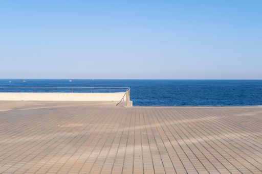 A scenic shot of an empty viewing deck overlooking the Mediterranean sea on the horizon