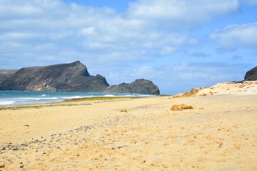 A breathtaking view of Porto Santo beach with a huge rock formation on the background