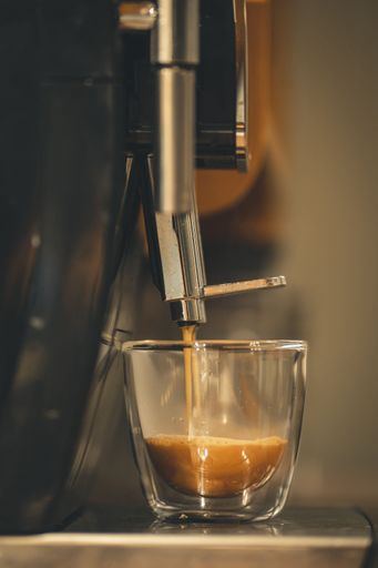 A closeup of espresso poured into a cup from a coffee machine