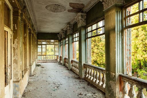 A closeup shot of an abandoned Mansion in Ajara, Georgia with blooming trees seen from balcony