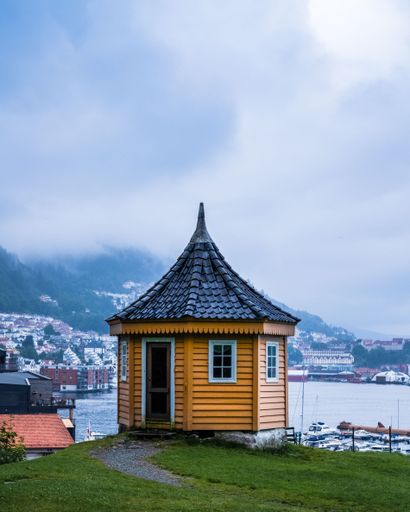 A vertical shot of a beautiful gazebo with mountains in the background in Bergen, Norway