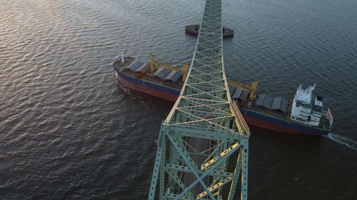 An aerial view of a freight ship sailing under the Columbia River bridge in Astoria, Oregon