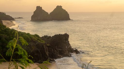 A scenic view of Praia do Boldro beach at sunset in Fernando de Noronha, Brazil