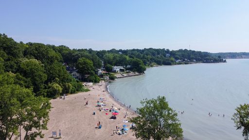 An aerial view of people vacationing on the sandy beach by Lake Erie in Port Stanley, Ontario, Canada