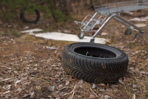 Illegal dumping of tyres and other stuff in the countryside. The concept of environmental pollution.