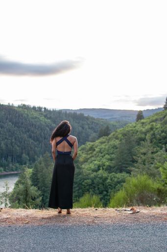 A vertical shot of a female enjoying forest mountain view