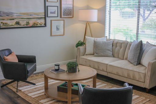A high-angle of living room interior with sofa chairs lamp wooden table in it
