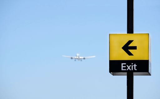 A shallow focus of a yellow exit sign with a left arrow