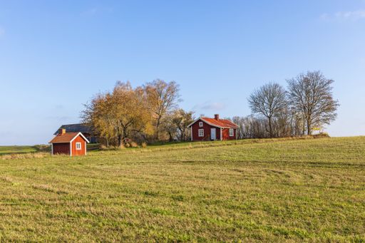 A scenic view of idyllic red cottages on a hill at autumn on a sunny day
