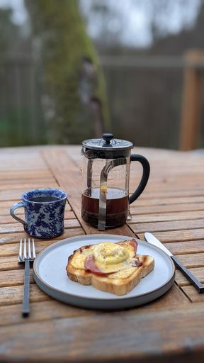 A vertical shot of delicious breakfast with eggs benedict and coffee