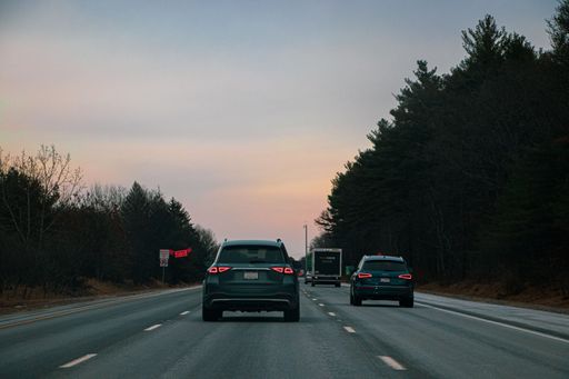 A beautiful shot of cars driving on a highway in Maine at sunset